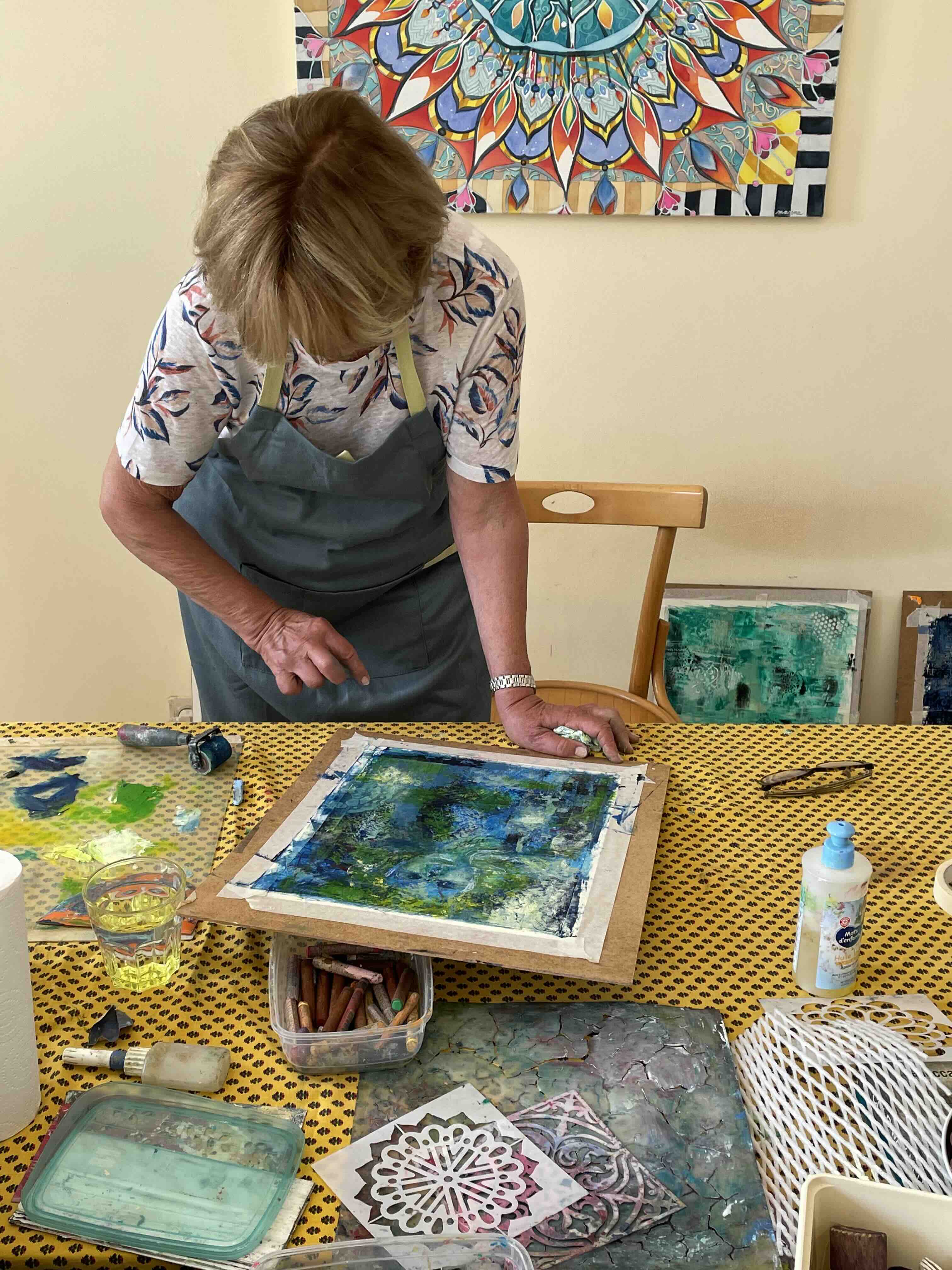 Student creating a textured cold wax painting